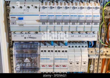 Close-up view of a modern electrical distribution board with labeled circuit breakers and connected wires Stock Photo