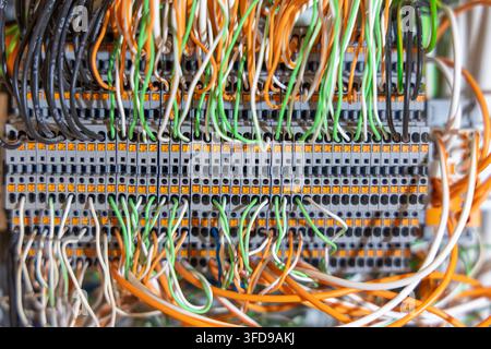 Intricate network of multi-colored wires connected to a gray terminal block, suggesting a sophisticated electronic setup Stock Photo