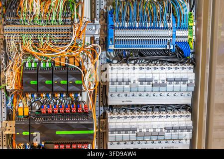 A detailed view of an industrial electrical control panel showcasing intricate wiring and multiple circuit breakers for power distribution Stock Photo