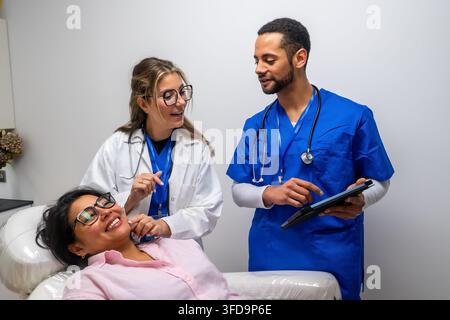 Medical professionals consulting patient using a digital tablet Stock Photo