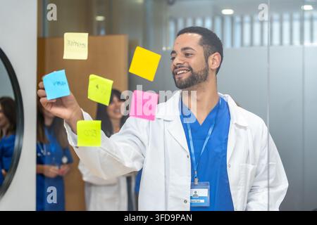 Medical professionals collaborating on patient care research using sticky notes Stock Photo