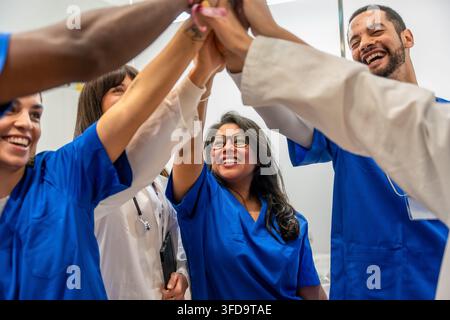Diverse medical team high fiving celebrating success together Stock Photo