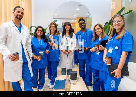 Diverse medical staff group posing in hospital hallway Stock Photo
