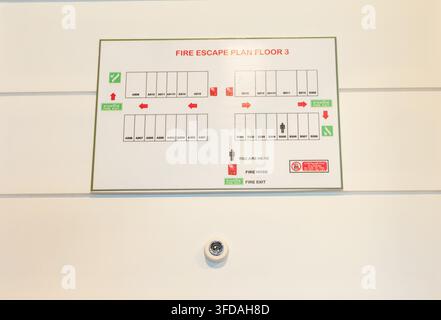 Fire escape plan map is located on the white hotel or resort door. Stock Photo