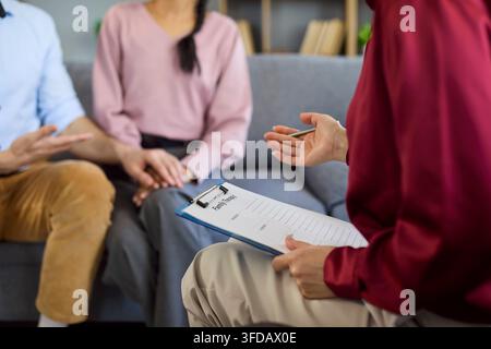 Therapist taking notes during couple counseling and relationship support session Stock Photo