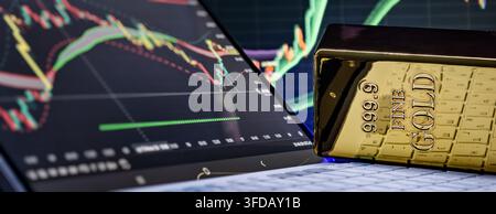 Online commodity trading concept. Gold bullion on computer keyboard against digital investment graph background. Stock Photo