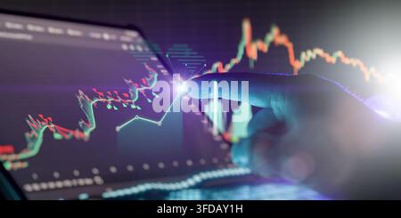 Interactive digital investment concept showing a hand pointing at virtual holographic business analytics and cryptocurrency graphs. Stock Photo