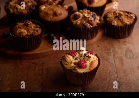 Homemade Raspberry Nut Muffins with Chocolate on Wooden Table Stock Photo
