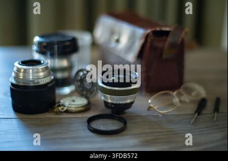 vintage retro camera lenses, old fashioned and retro pocket watch with lid on wooden table Stock Photo