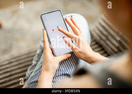 GNIEZNO, POLAND - May 06, 2026: Women's Hands Holding A Phone With The Youtube Studio Logo On The Screen Stock Photo