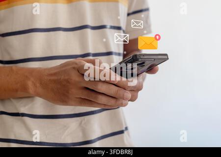 A man using a smartphone with digital email or message notification Stock Photo