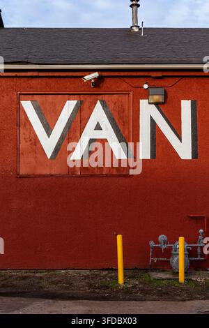 Red exterior wall with large painted white letters VAN on the Vancouver Flea Market in Vancouver, British Columbia. Stock Photo