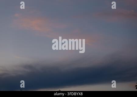 Soft dusk sky with dramatic blue cloud band and pastel colors Stock Photo