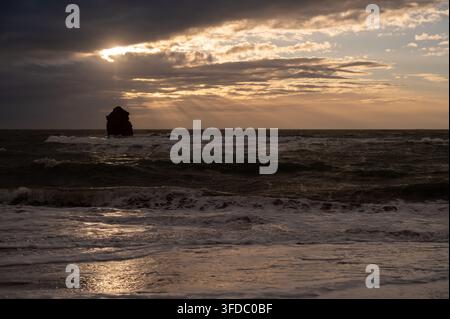Sun rays breaking through cloud over Thurlestone Rock at sunset, South Devon, England, 15 February 2026 Stock Photo