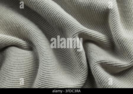 Grey ribbed fabric creating a textured background with soft folds Stock Photo