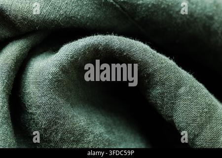 Green linen fabric material creating a soft crumpled textile background with textured surface Stock Photo