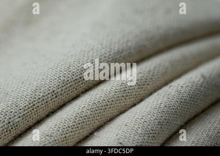 Beige linen fabric showing a detailed natural textile weave and soft folds Stock Photo