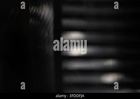 blurred black background with soft horizontal light bands and mesh shadow for abstract modern design or dark backdrop Stock Photo