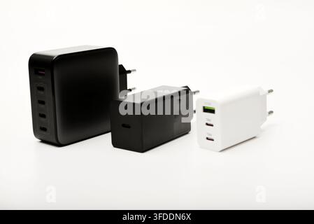 Black and white power supplies for mobile devices. Powerful power supplies on a white background. Charging devices for gadgets. Stock Photo