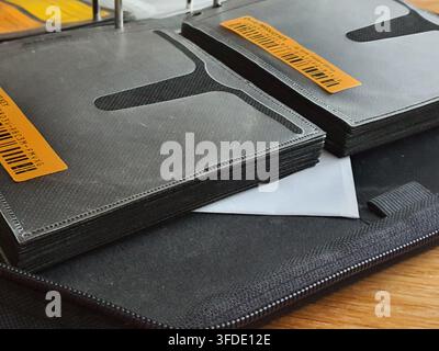 Close-up view of black CD or DVD storage sleeves stacked in an open disc wallet organizer with metal binder rings visible at the top. The textured Stock Photo