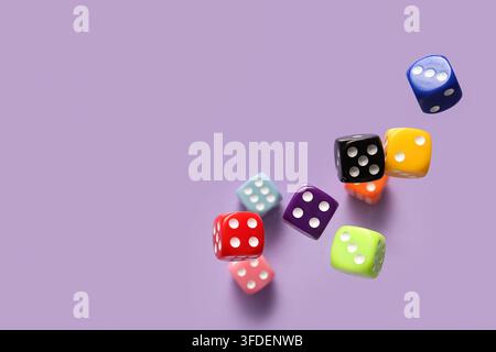 Flying colorful game dices on lilac background Stock Photo