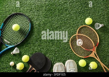 A collection of table tennis paddles and balls arranged on the surface ...