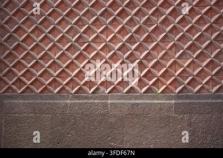 Horizontal background texture of wall with geometric terracotta tiles and rustic stone base Stock Photo