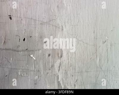 Weathered grey painted wall texture featuring fine scratches, smudges and worn brush strokes for abstract rustic background design. Stock Photo