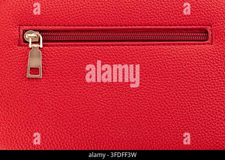 Macro close up of golden zipper on red leather texture background Stock Photo