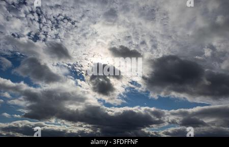 Dramatic cloud formations filling the sky with sunlight breaking through Stock Photo
