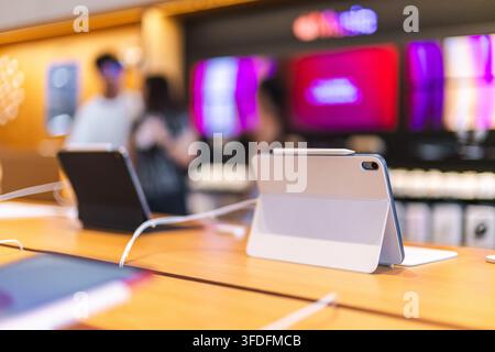 Tablet Computers on Wooden Display Table with Blurred Shoppers Stock Photo