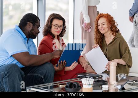 Diverse colleagues reviewing documents in a meeting Stock Photo
