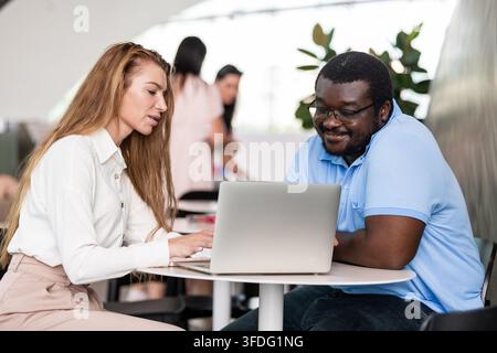 Diverse coworkers collaborating on a laptop computer Stock Photo