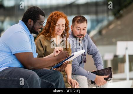 Diverse team of colleagues collaborating outdoors Stock Photo