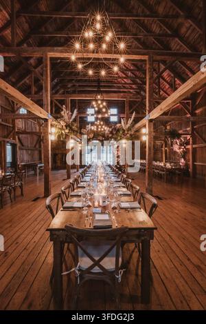 Long table set for rustic barn wedding reception Stock Photo