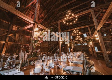 Elegant wedding reception table set in rustic barn Stock Photo