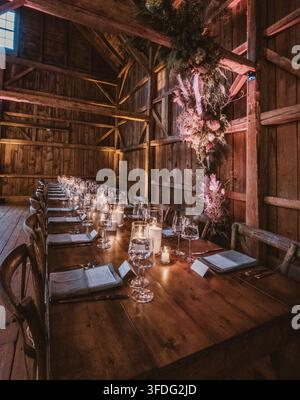 Elegant rustic dinner table set inside a barn Stock Photo