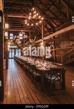 Long dining table set for a rustic barn wedding Stock Photo