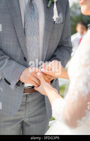 Newlywed couple holding hands at their wedding ceremony Stock Photo