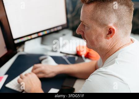 Focused man with mustache typing on computer Stock Photo