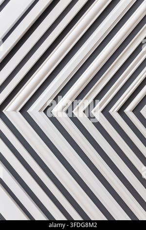 Close-up of white plastic slats forming a repeating diagonal pattern against a dark background. Stock Photo