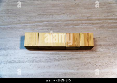 Top view of five blank wooden cubes lined up on a light wooden background. Copy space for text, word, date, or mockup. Stock Photo