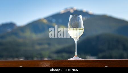 Glass of White Wine on Cruise Ship with Scenic Alaska Mountain Background Stock Photo
