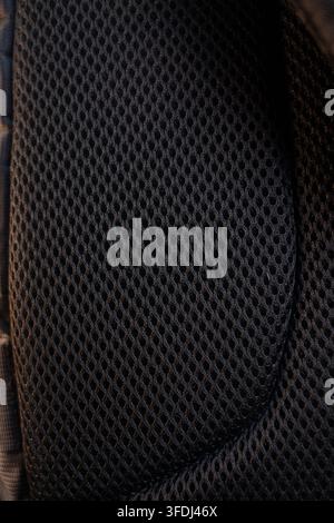 Black breathable mesh fabric surface creates a detailed pattern close up. Macro structure conveys durability material quality and modern comfort. Stock Photo