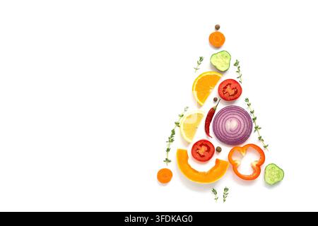 Christmas tree made of pieces of vegetables and fruits on a white background. The concept of vegan and vegetarian food. Top view, flat lay, copy space. Creative layout Stock Photo