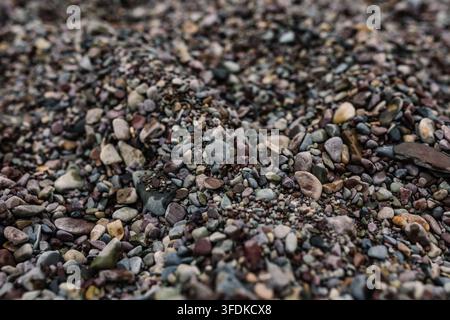 Close-up of colorful smooth pebbles and stones on a natural rocky shoreline Stock Photo