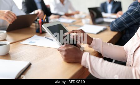 Closeup Of Tablet In Businesswoman's Hands During Corporate Meeting Indoor Stock Photo