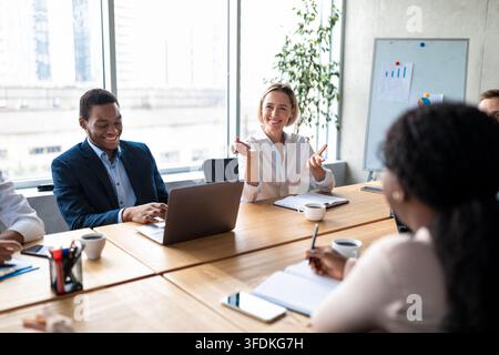 Cheerful Colleagues Talking Brainstorming Project Idea Working Sitting In Office Stock Photo