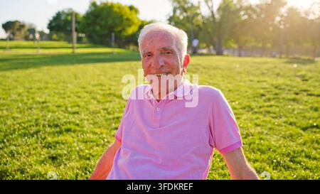 Senior man smiling enjoying retired healthy lifestyle in park Stock Photo