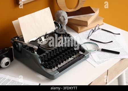Creative writing and storytelling concept vintage typewriter with paper and books on a desk for journalism literature and historical research projects Stock Photo
